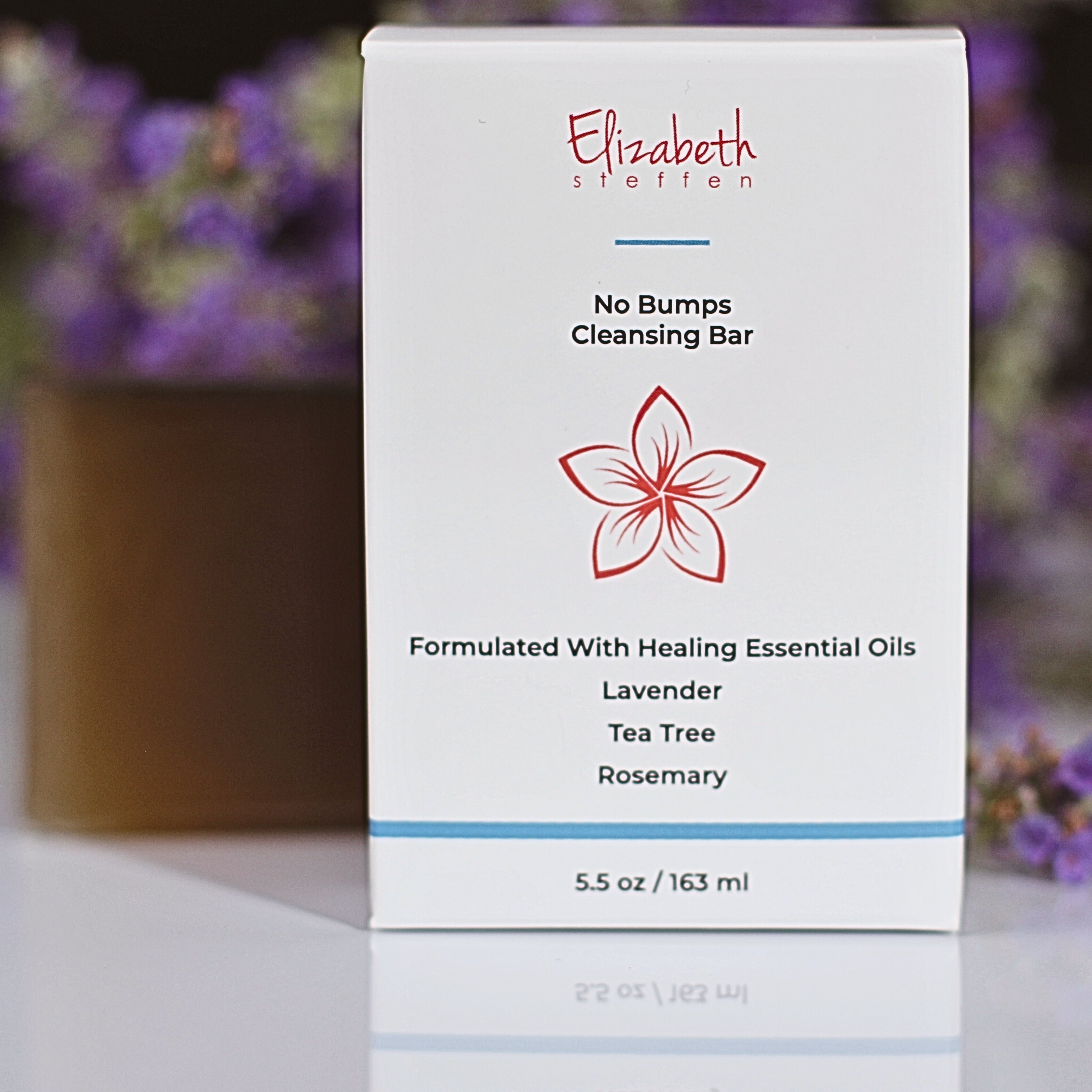 the box of soap with the bar in the background with lavendar